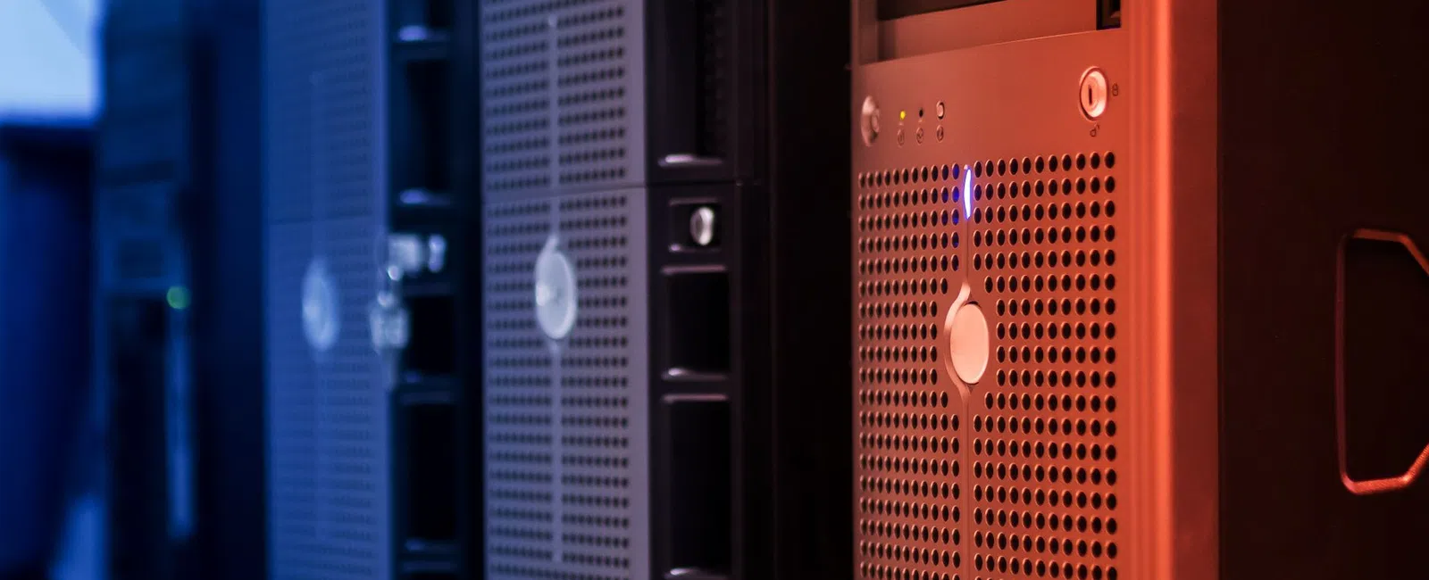 Close-up of multiple black computer servers with ventilation grilles in a data center rack.