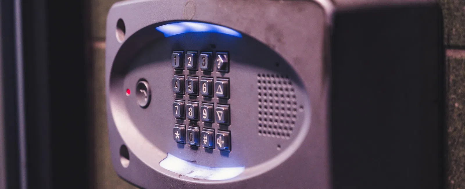 Security keypad with illuminated buttons mounted on a wall for controlled access entry.