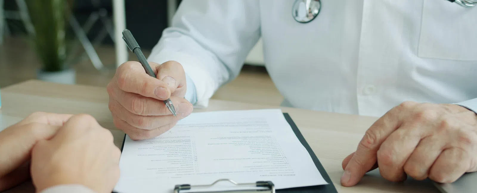 Doctor in white coat filling out a medical form on clipboard during a HIPAA compliance audit