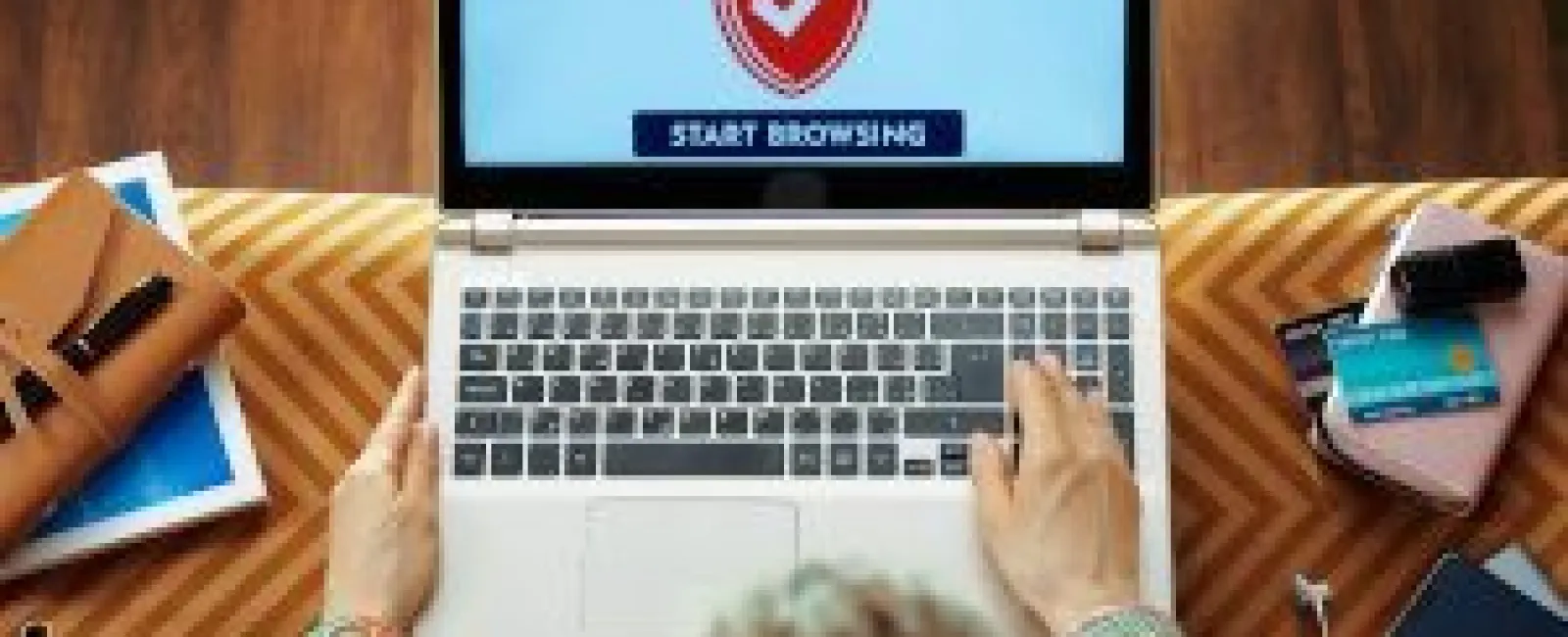 Person using a laptop displaying secure browser screen with shield icon and start browsing button.