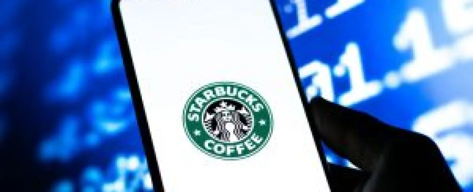 Smartphone displaying Starbucks Coffee logo with blue digital data background and silhouette hand in foreground