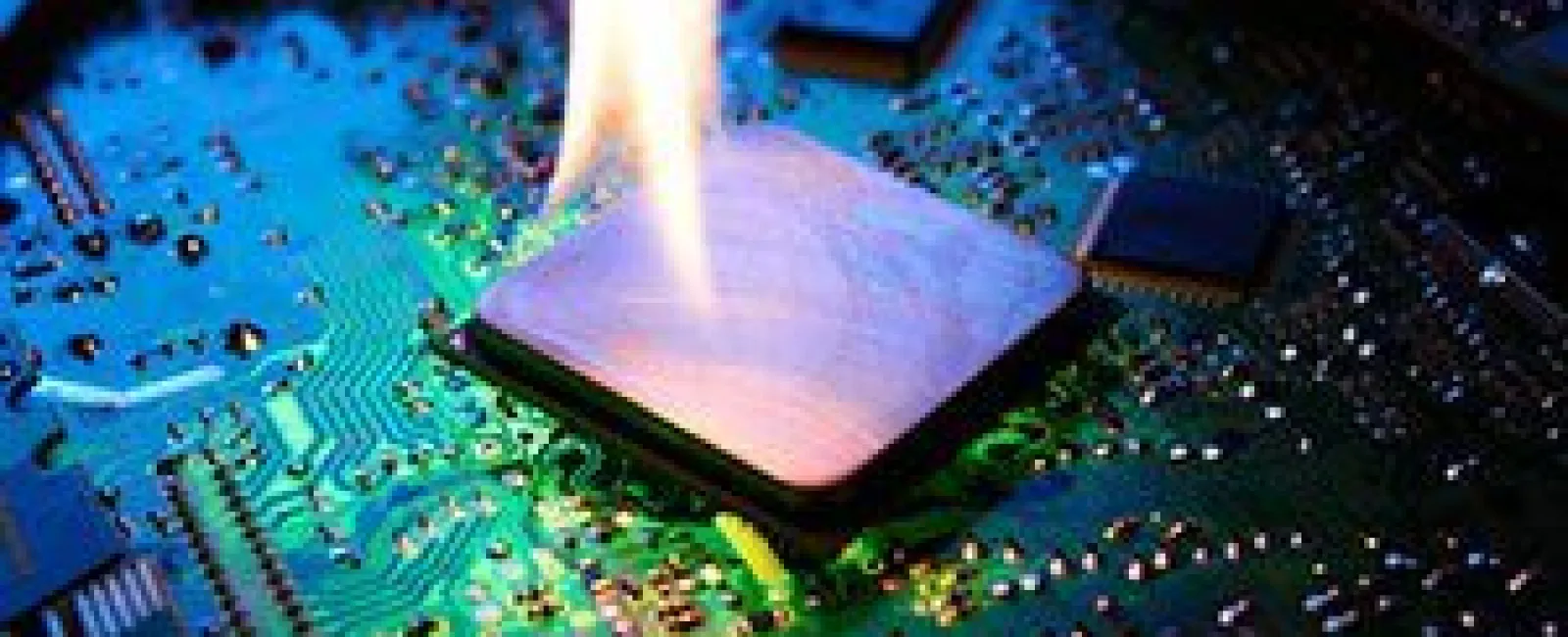 Computer processor chip on a circuit board overheating with a flame indicating damage or failure