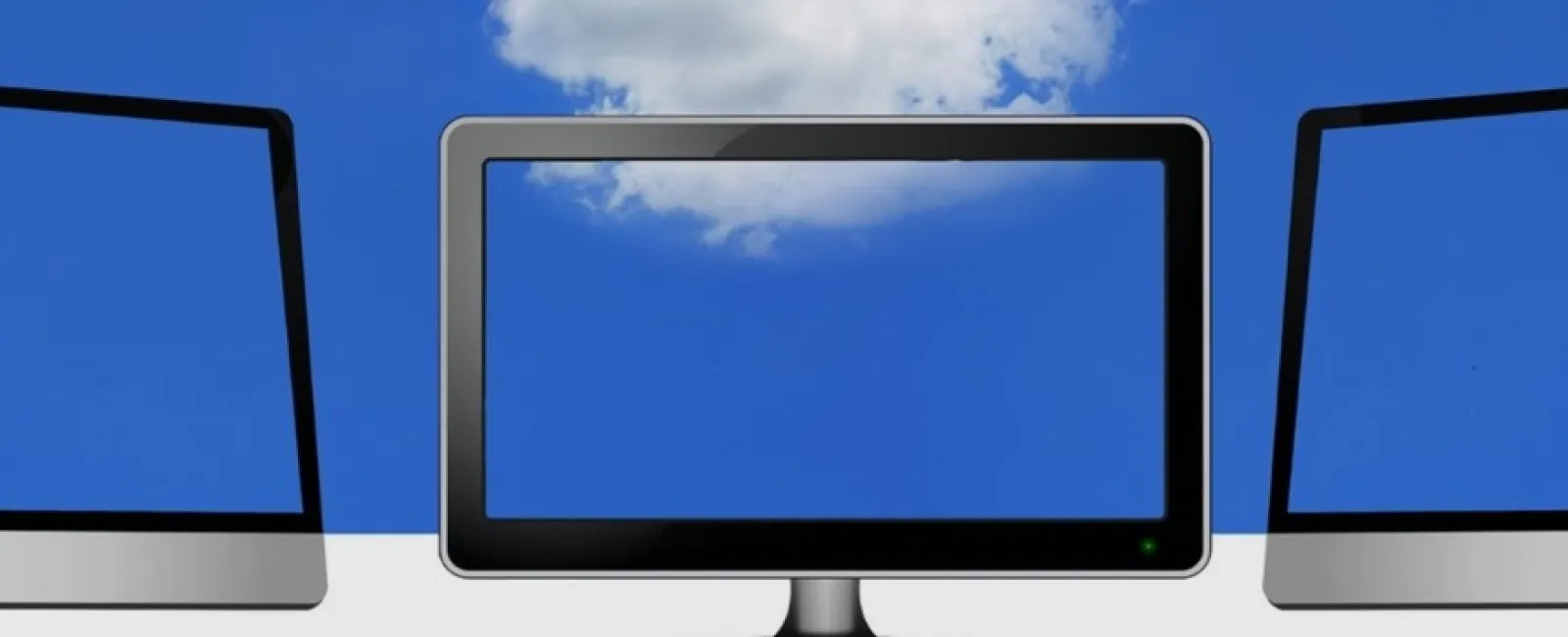 Three modern computer monitors with blue screens against a blue sky with clouds background.