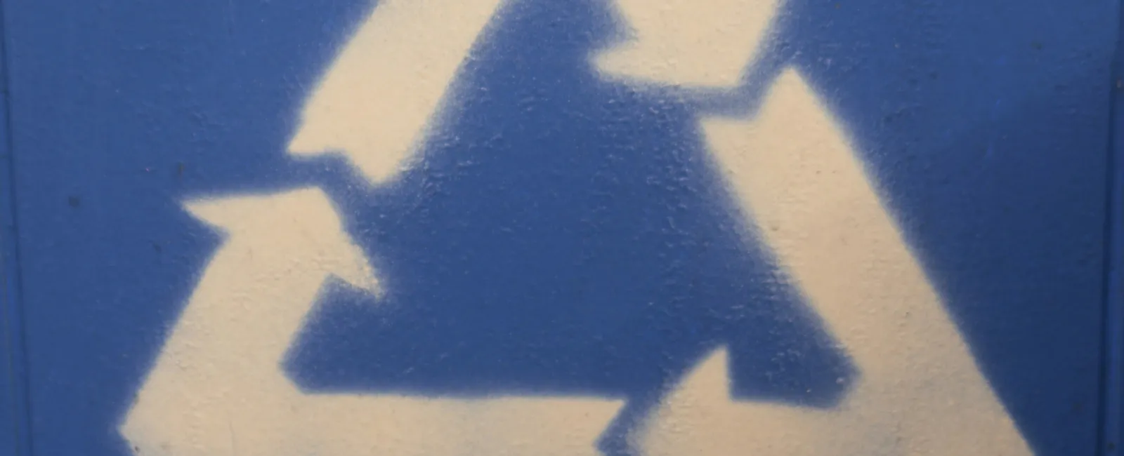 White recycling symbol with three arrows forming a triangle on a blue textured background.