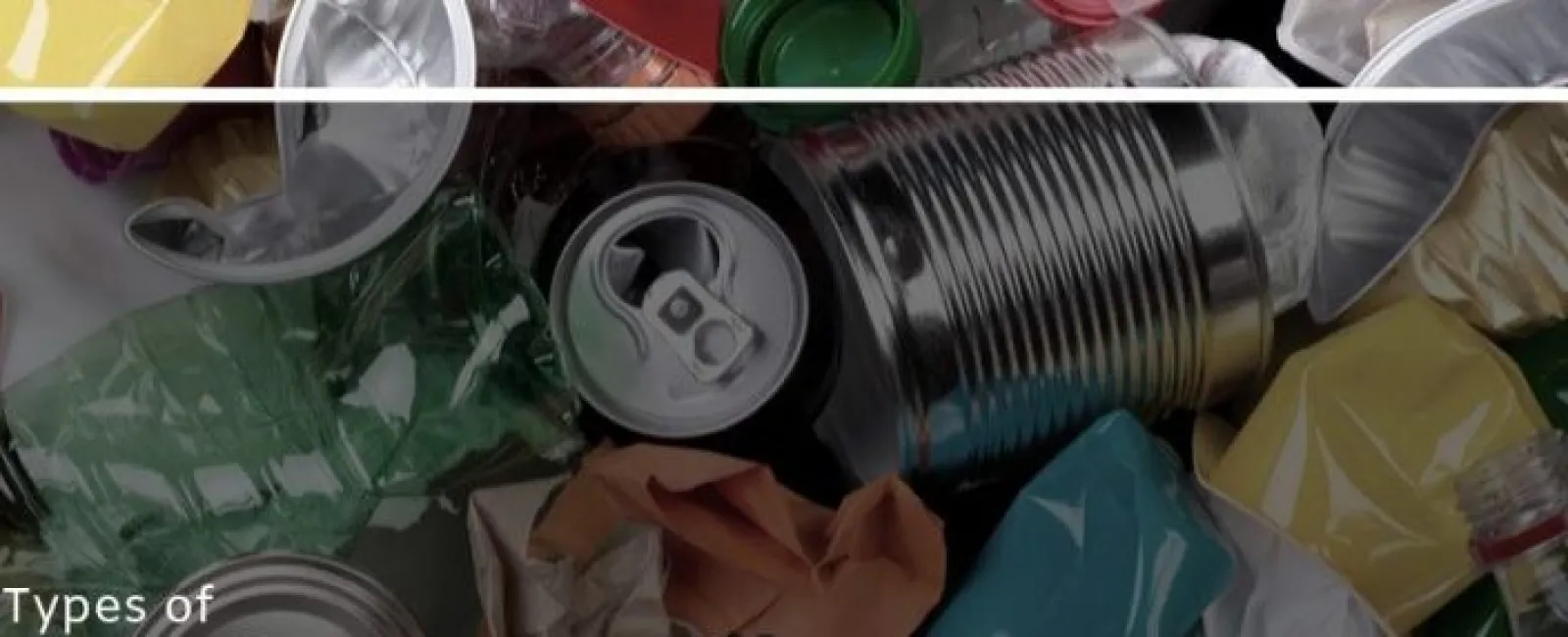 Various crushed and empty plastic bottles, aluminum cans, and tin containers piled together for recycling.