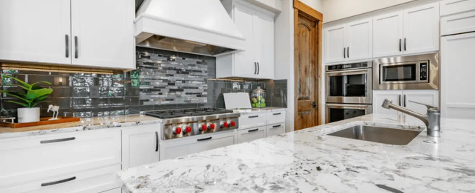 Modern kitchen with marble countertops, stainless steel appliances, and sleek cabinetry.