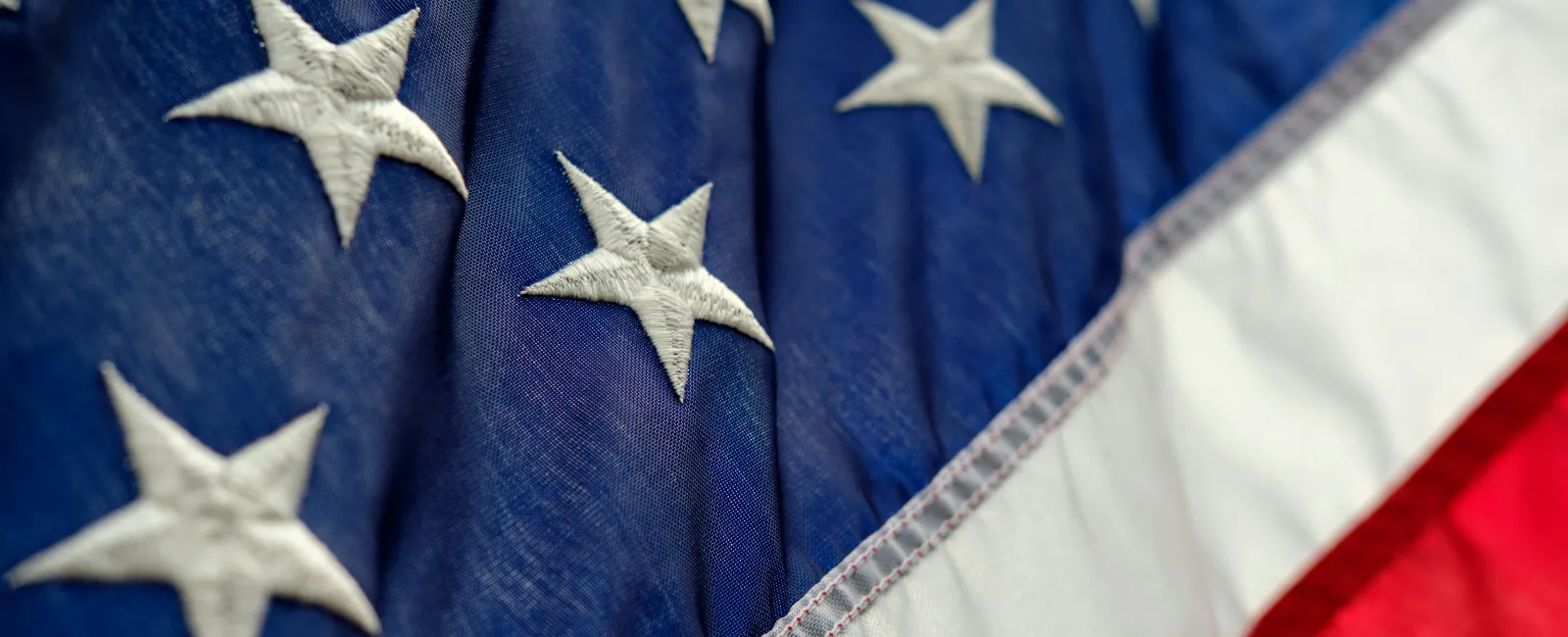 Close-up of the American flag Mortgage Loans for Veterans with Bad Credit in Orlando, FLars on blue and red and white stripes fabric.
