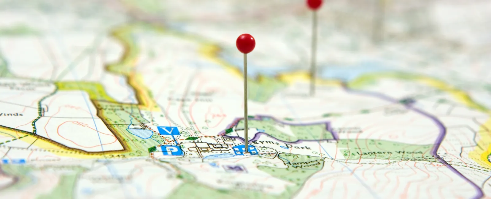 Red pins marking specific locations on a detailed geographical map with contour lines and landmarks.