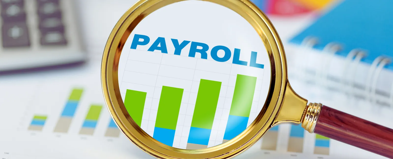 Magnifying glass highlighting a payroll bar chart on financial documents with graphs and calculator in background