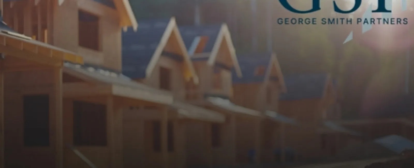 Wooden houses under construction in a row with George Smith Partners logo overlay on a sunny day