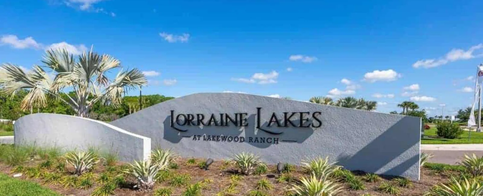 Entrance sign for Lorraine Lakes at Lakewood Ranch with landscaping under a blue sky.