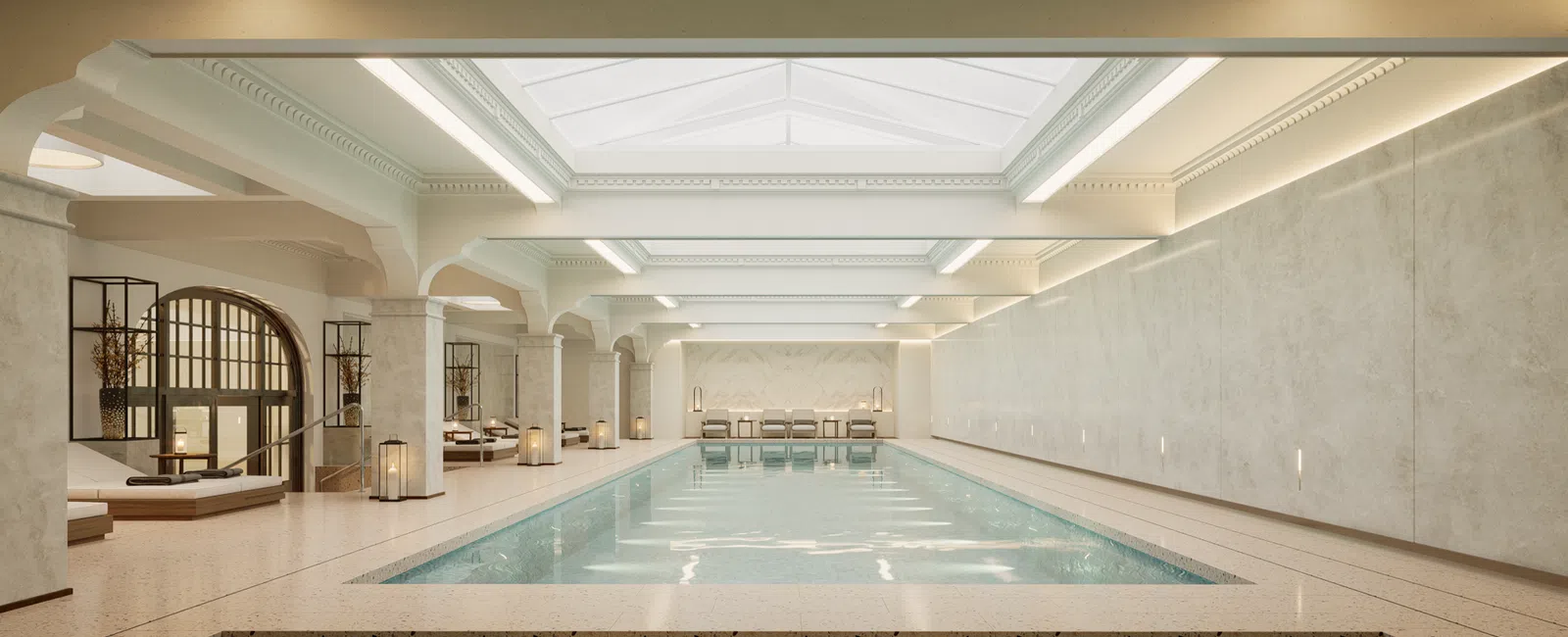Luxurious indoor pool area with large skylights, neutral tones, and modern minimalist decor.
