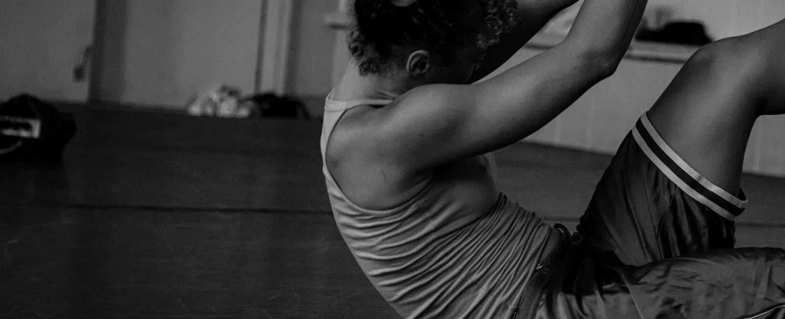 Woman performing core exercises on gym floor in athletic wear, focusing on strength and fitness training.