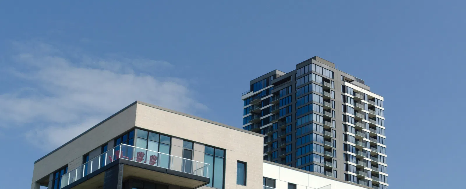 Modern apartment buildings with glass balconies under a clear blue sky during daytime
