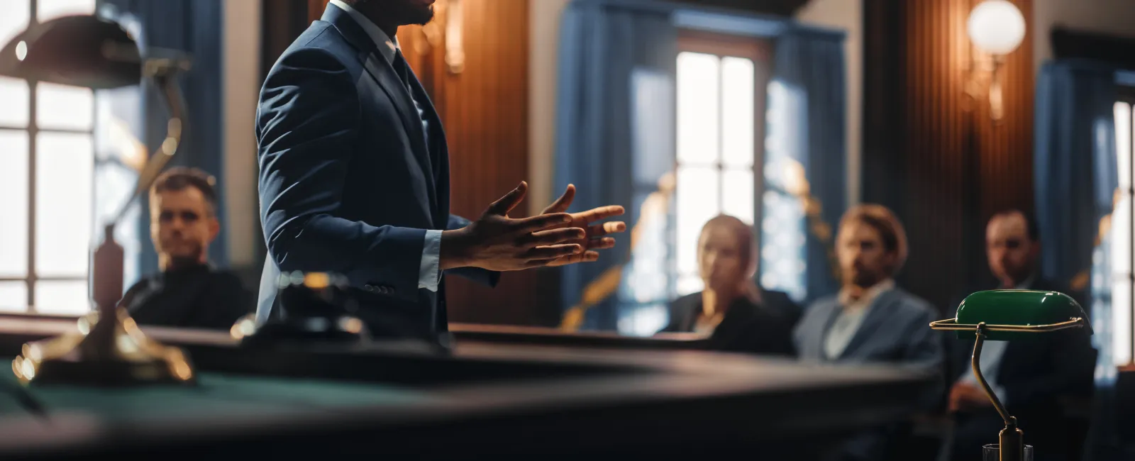 Confident lawyer presenting a case in courtroom with attentive jurors in background during trial session