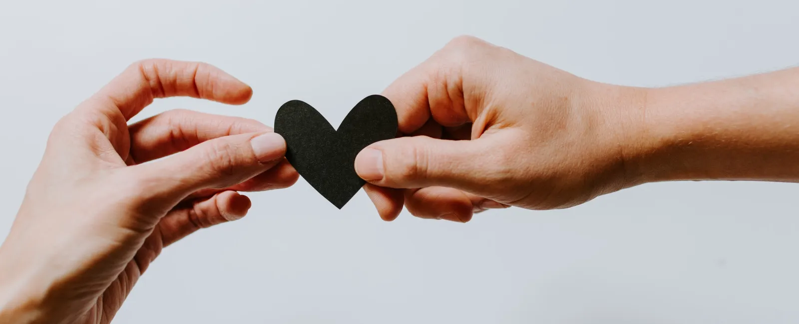 a pair of hands holding a black object