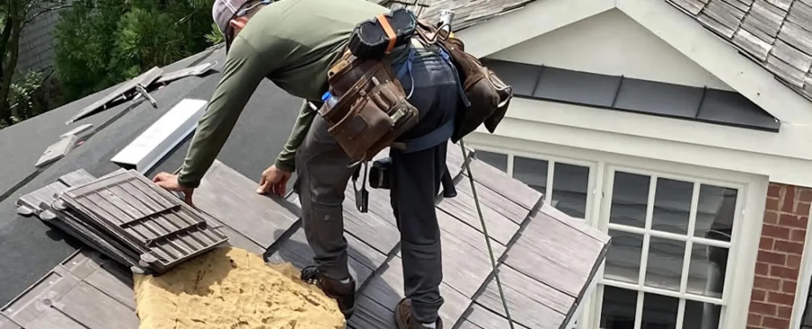 a couple of men working on a roof