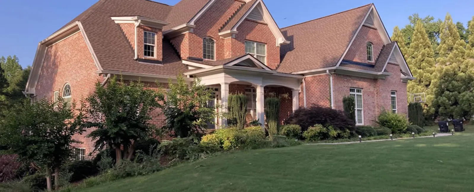 a large brick house with a lawn in front of it