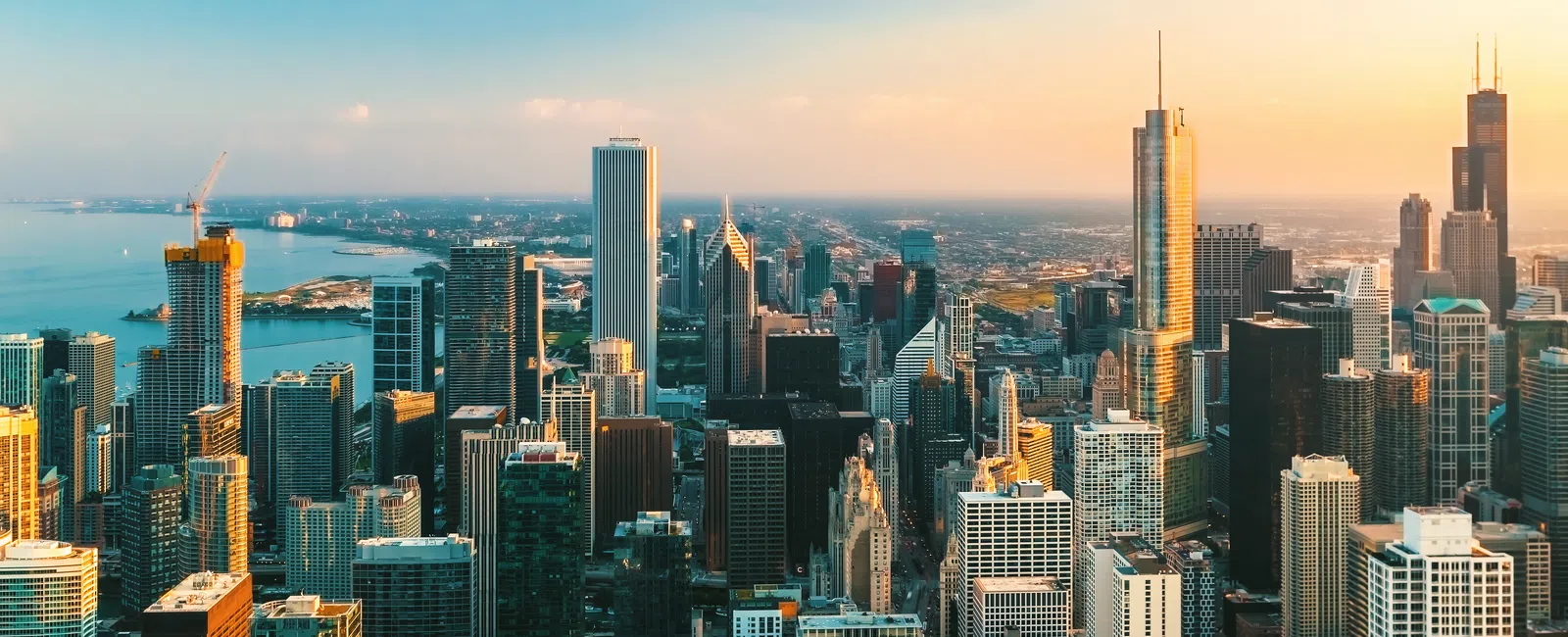Aerial view of Chicago skyline at sunset with high-rise buildings and Lake Michigan in the background