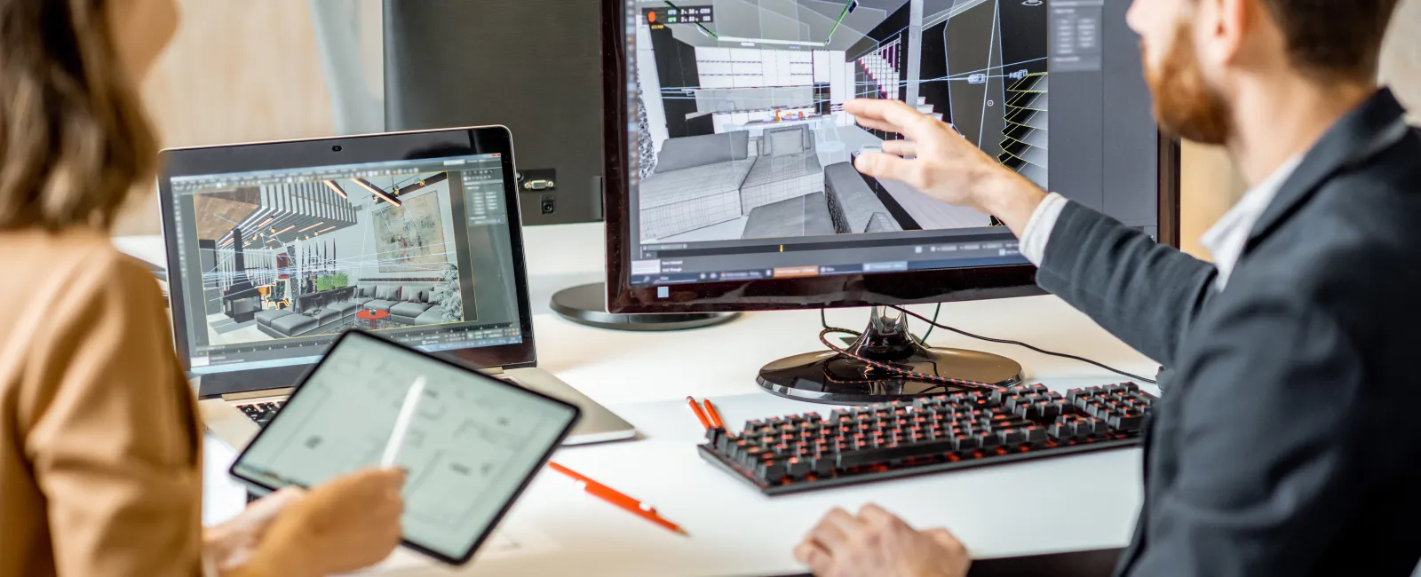 Two professionals collaborating on interior design projects using computer and tablet screens with 3D room models.