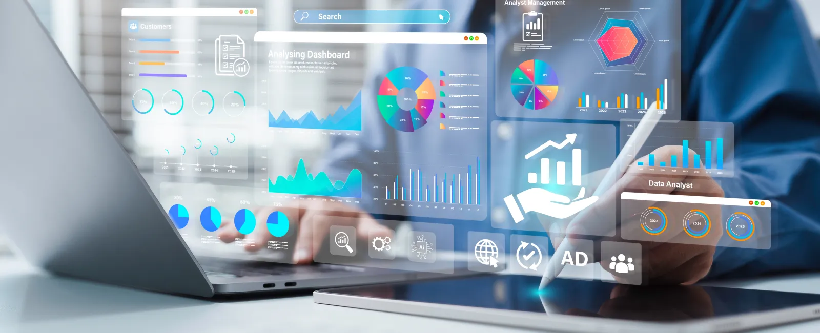 Person using laptop and tablet with digital business analytics and data visualization charts on screen