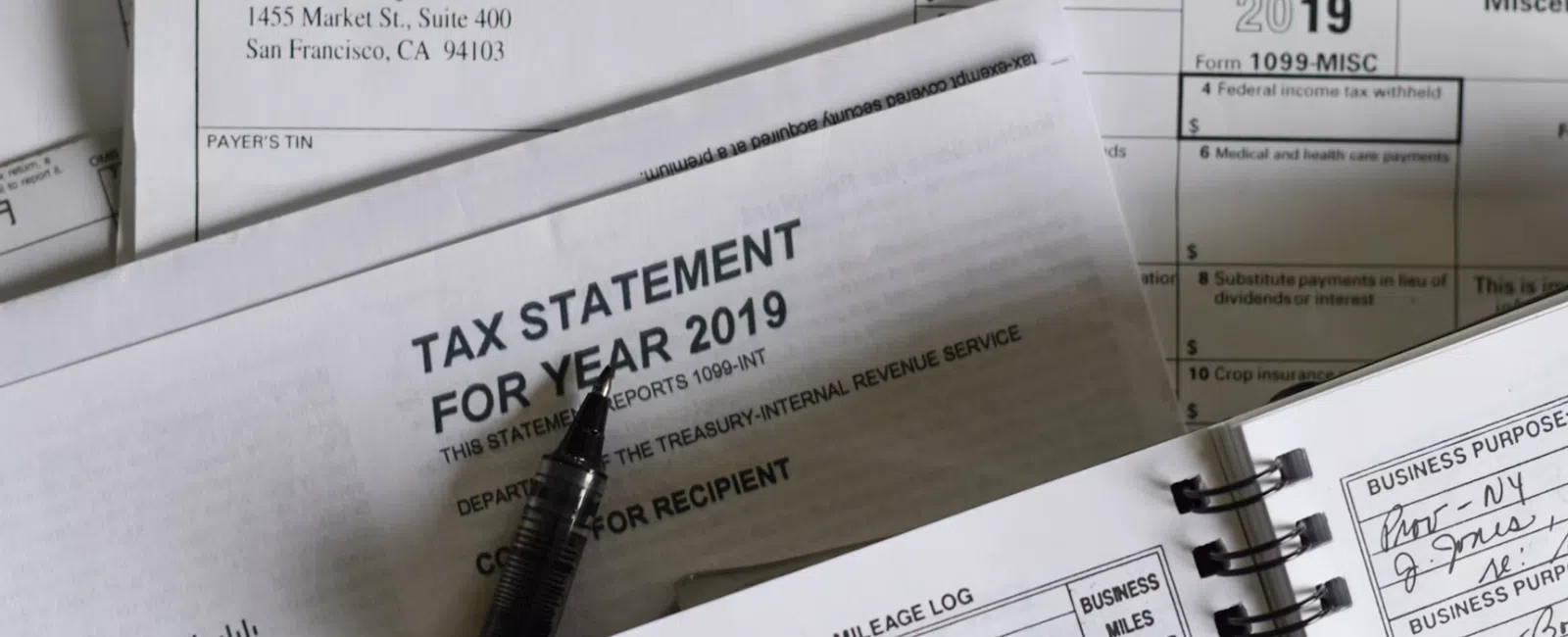 2019 tax statement and mileage log with pen, showing business miles traveled and tax form details