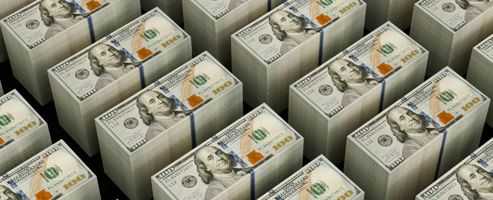 Stacks of US 100 dollar bills bundled and arranged in neat rows on a black surface.