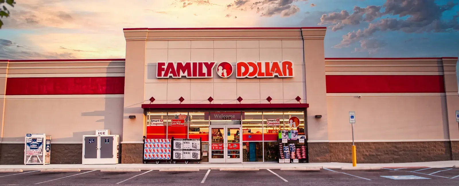 Family Dollar store exterior with signage and parking lot under a colorful evening sky.
