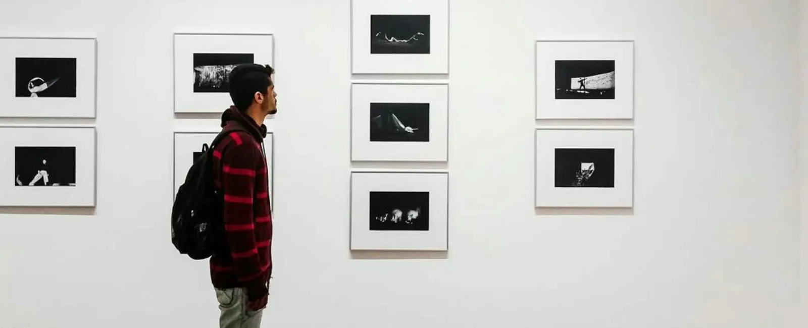 a person standing in front of a wall of pictures
