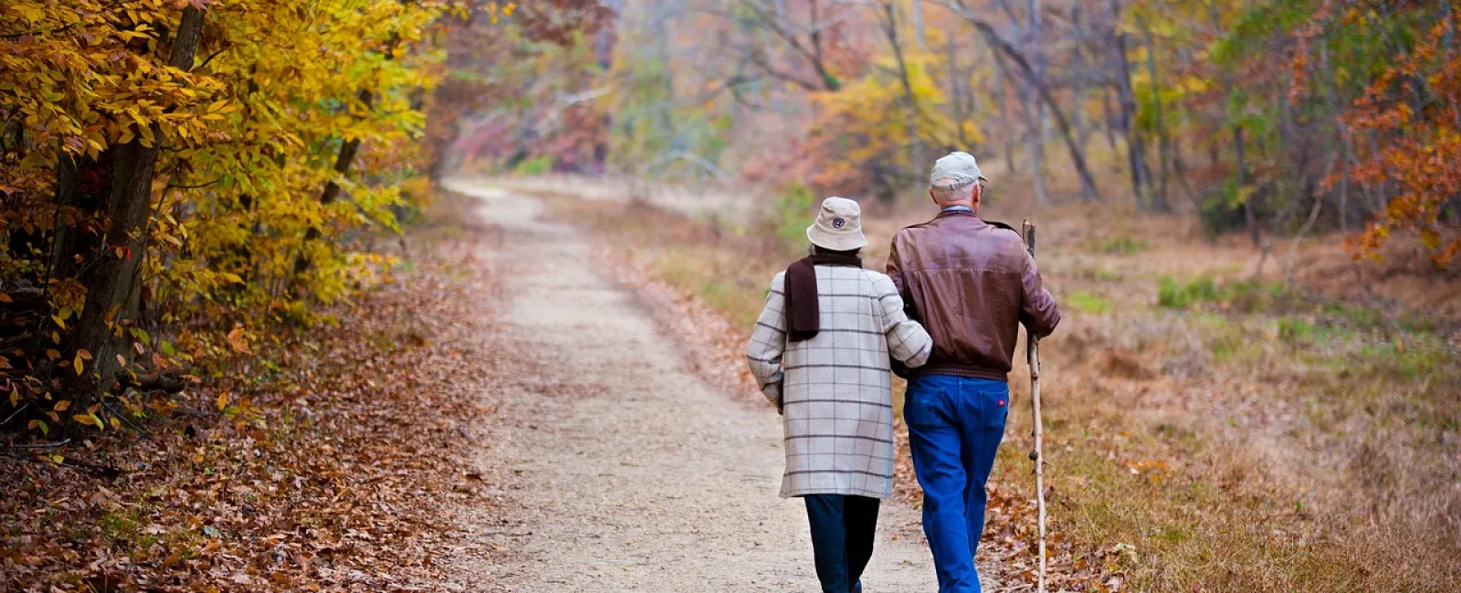 a couple walking on a dirt road