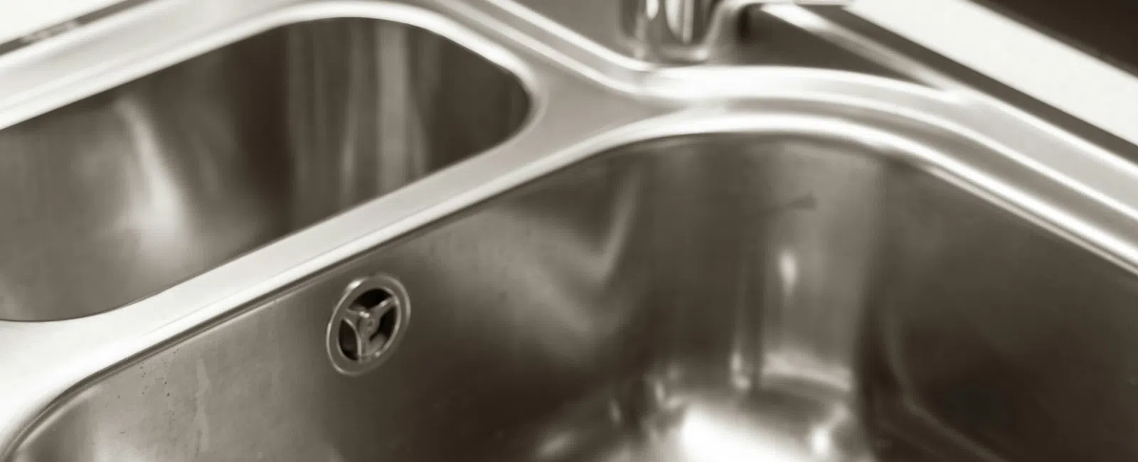 Modern stainless steel double kitchen sink with sleek chrome faucet and clean countertop.