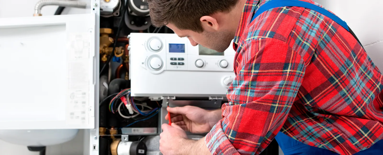 Technician servicing a heating system, focused on maintenance and repair tasks in a residential setting.