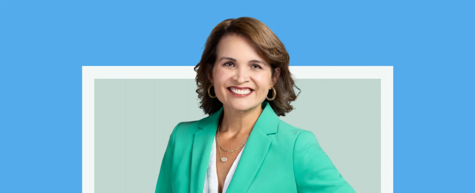 Professional portrait of Maggie Rosa, General Manager & VP of Operations, wearing a green blazer and smiling.