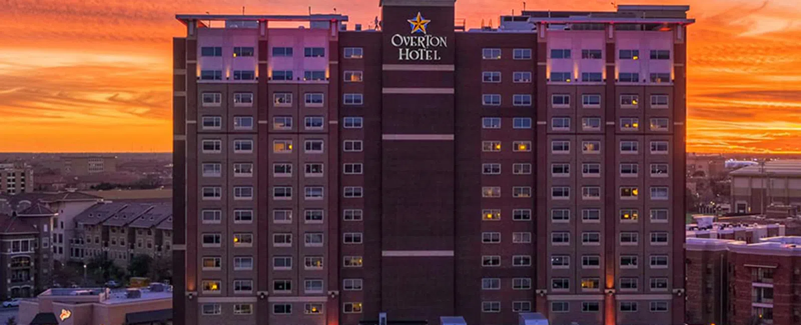 Overton Hotel building at sunset with dramatic orange and purple sky in the background