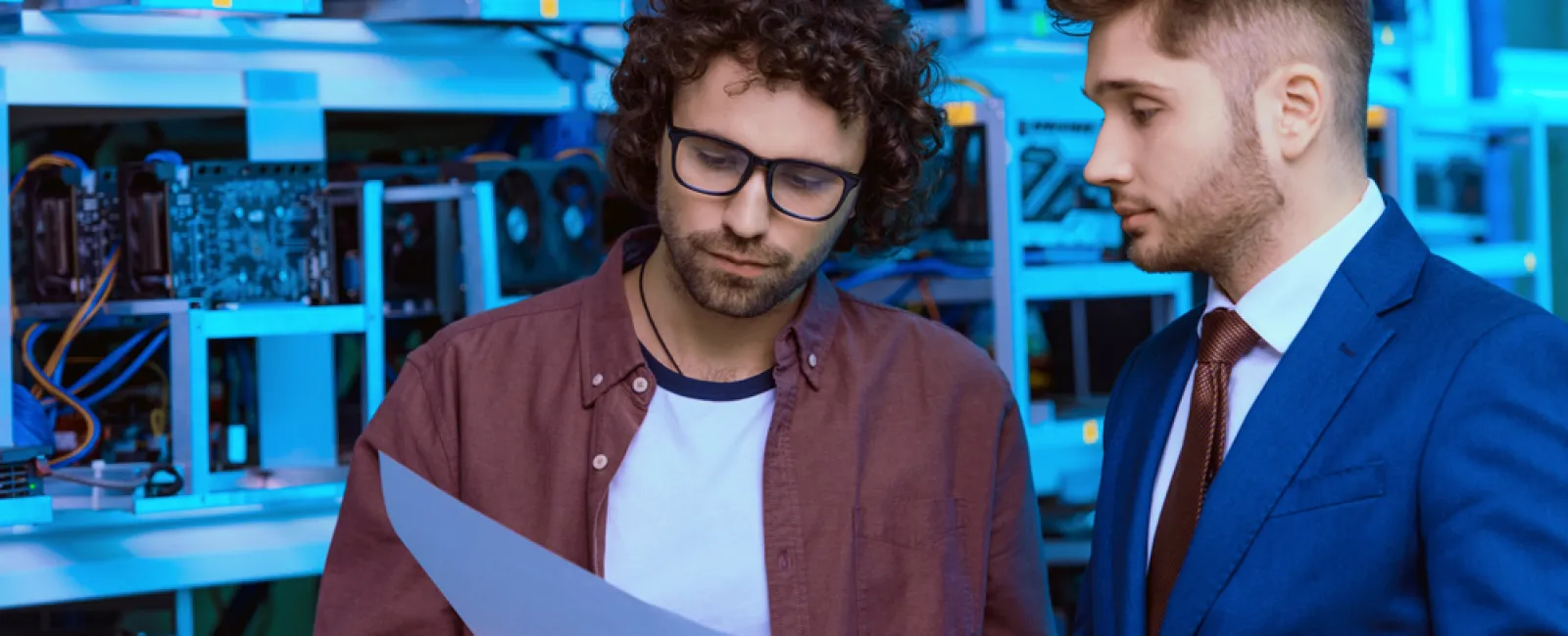 a couple of men looking at a sheet of paper