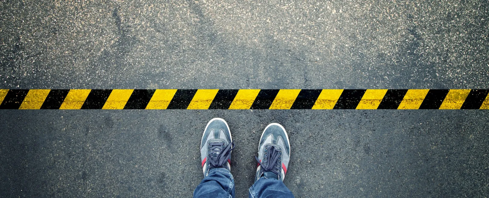 a person's legs and feet on a yellow and black striped surface