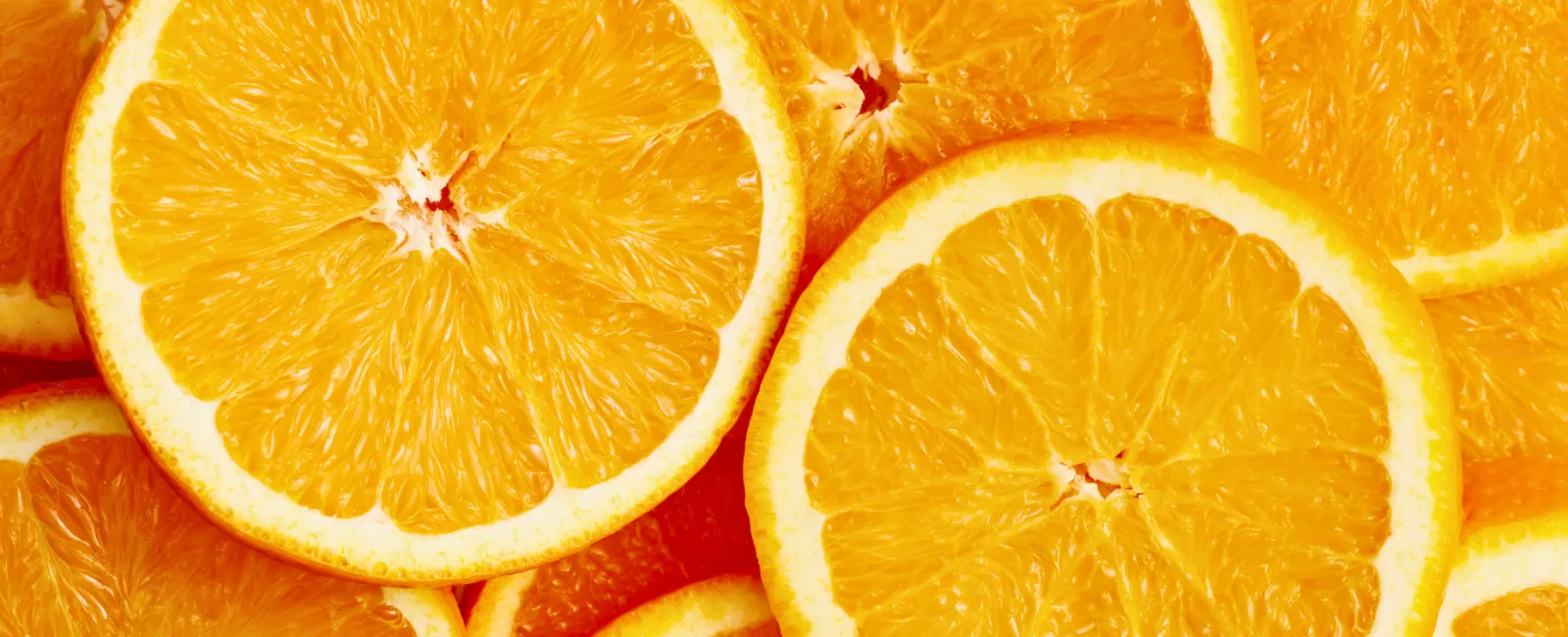 Close-up of multiple fresh orange slices showing juicy texture and vibrant color.