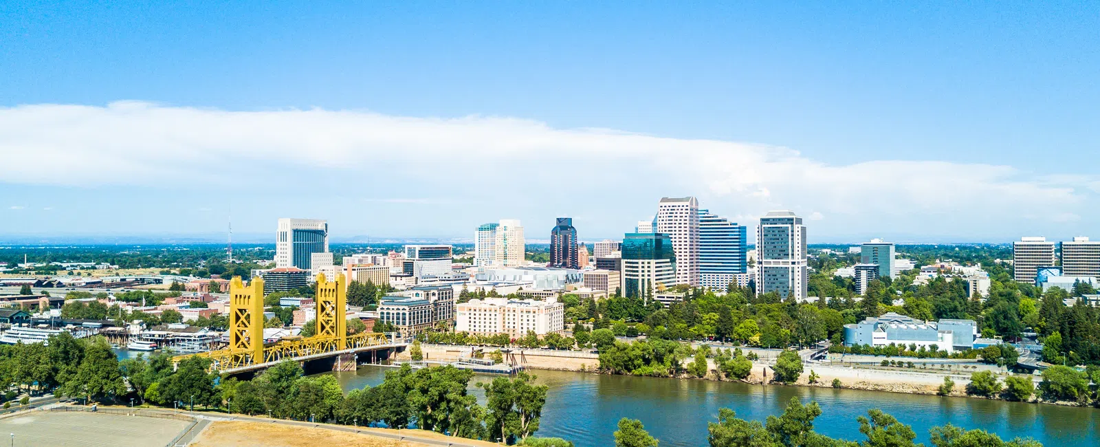 Sacramento city skyline with Tower Bridge over the Sacramento River under clear blue sky