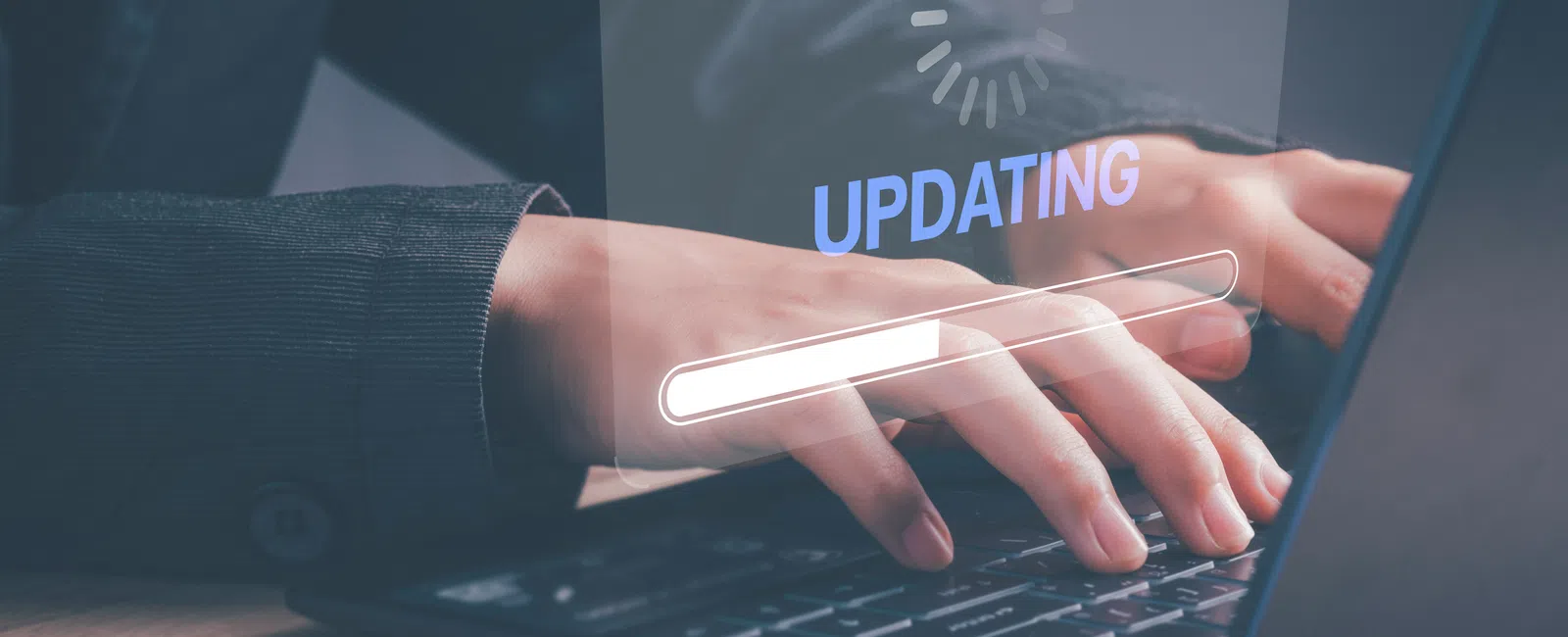 Person typing on laptop with digital update progress bar and loading icon over keyboard