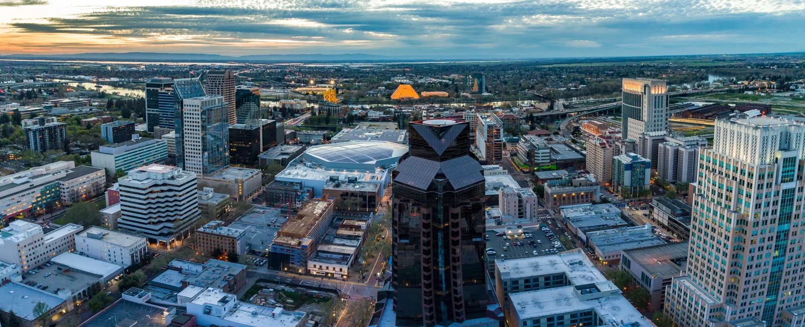 Aerial view of downtown Sacramento skyline at sunset with skyscrapers and cloudy sky