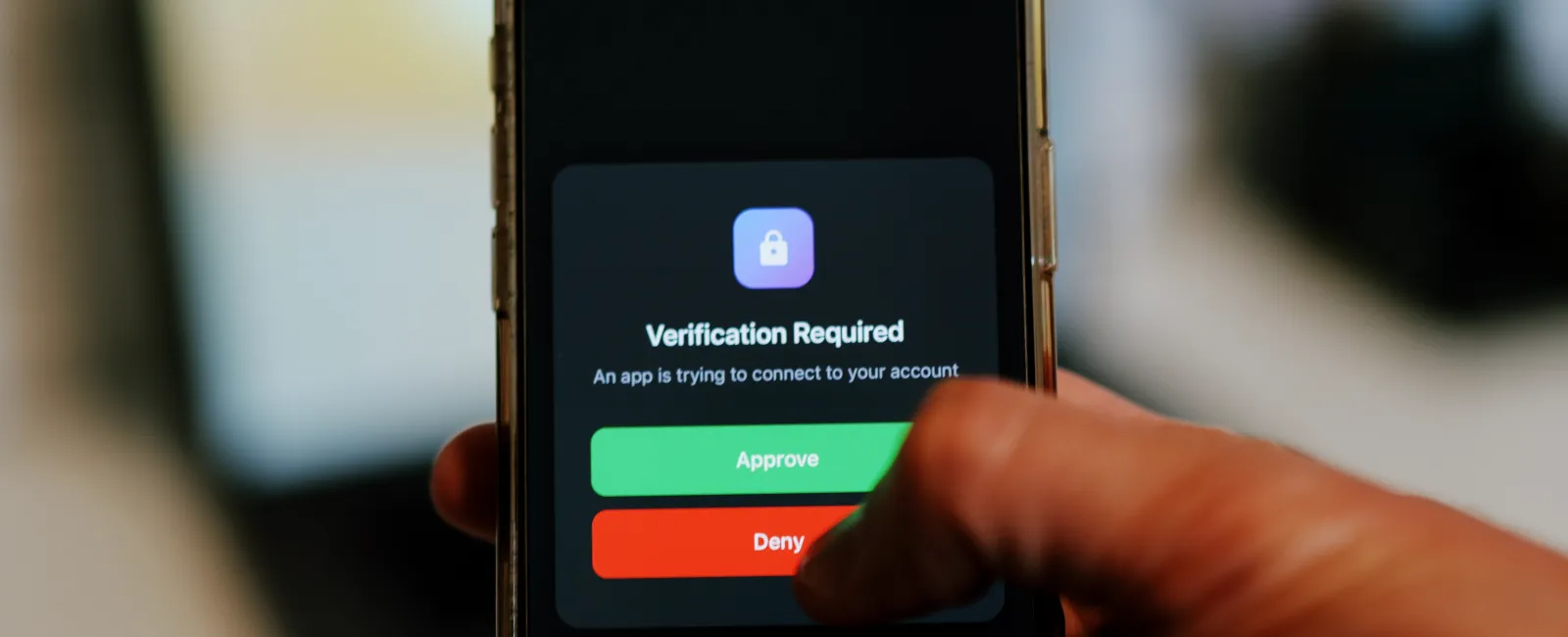 Smartphone screen showing two-factor authentication prompt with Approve and Deny buttons being selected.