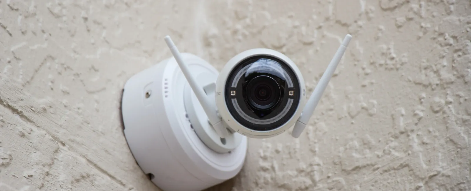 a white security camera on a wall