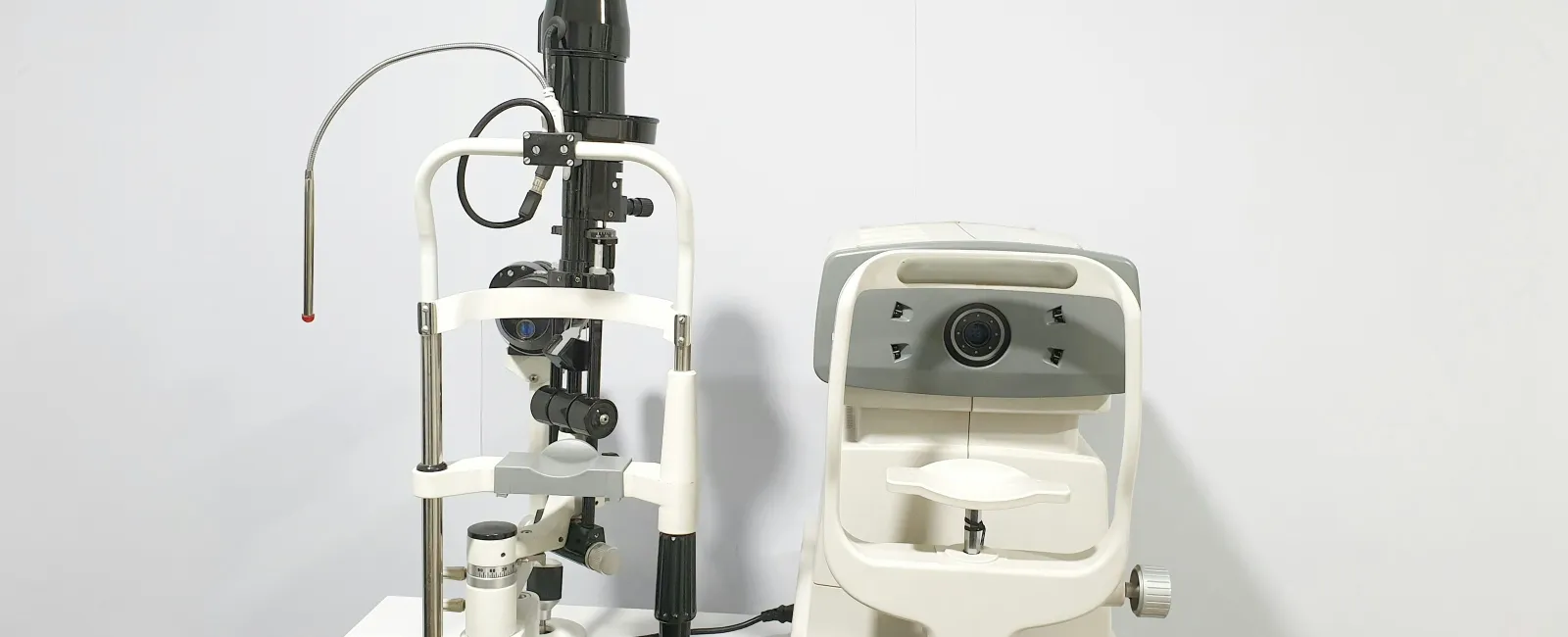 Modern eye examination equipment including slit lamp and autorefractor on a white background