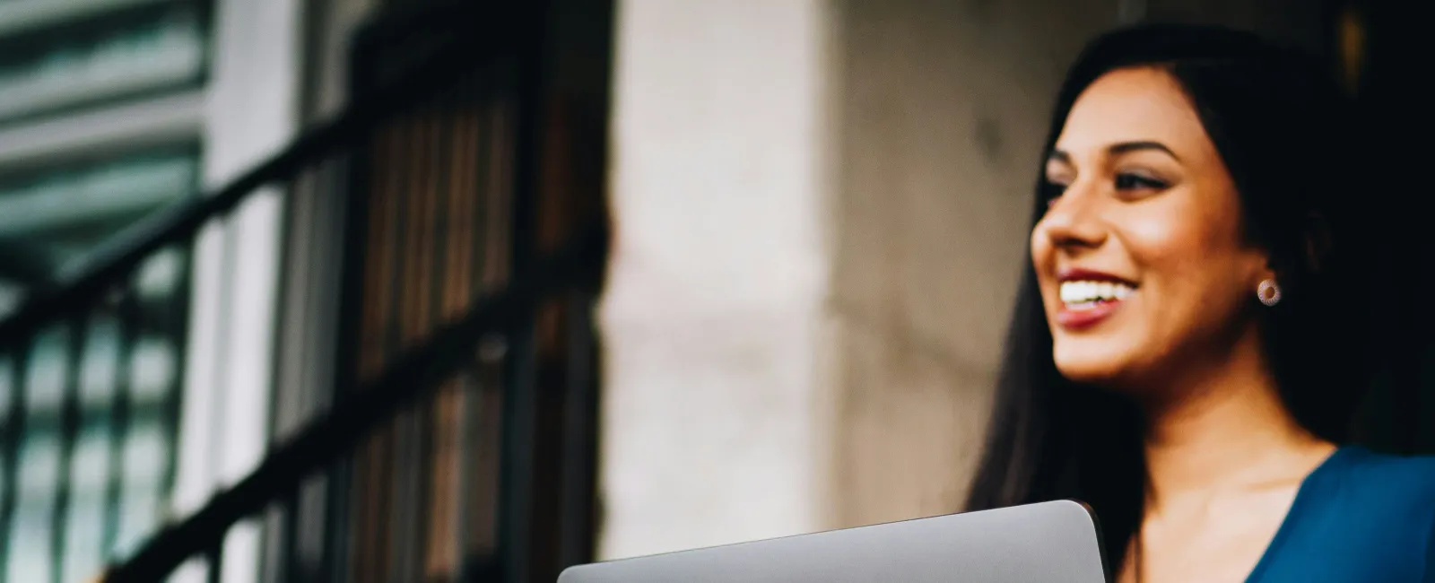 Woman smiling while using a digital point-of-sale system to process a coffee and avocado toast payment