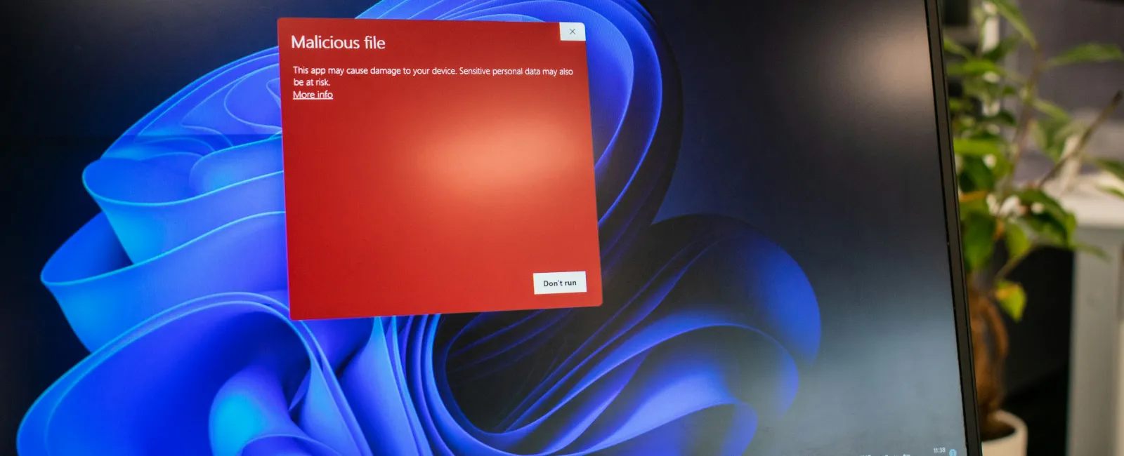 Dell laptop displaying a red warning of a malicious file on a Windows 11 desktop background.