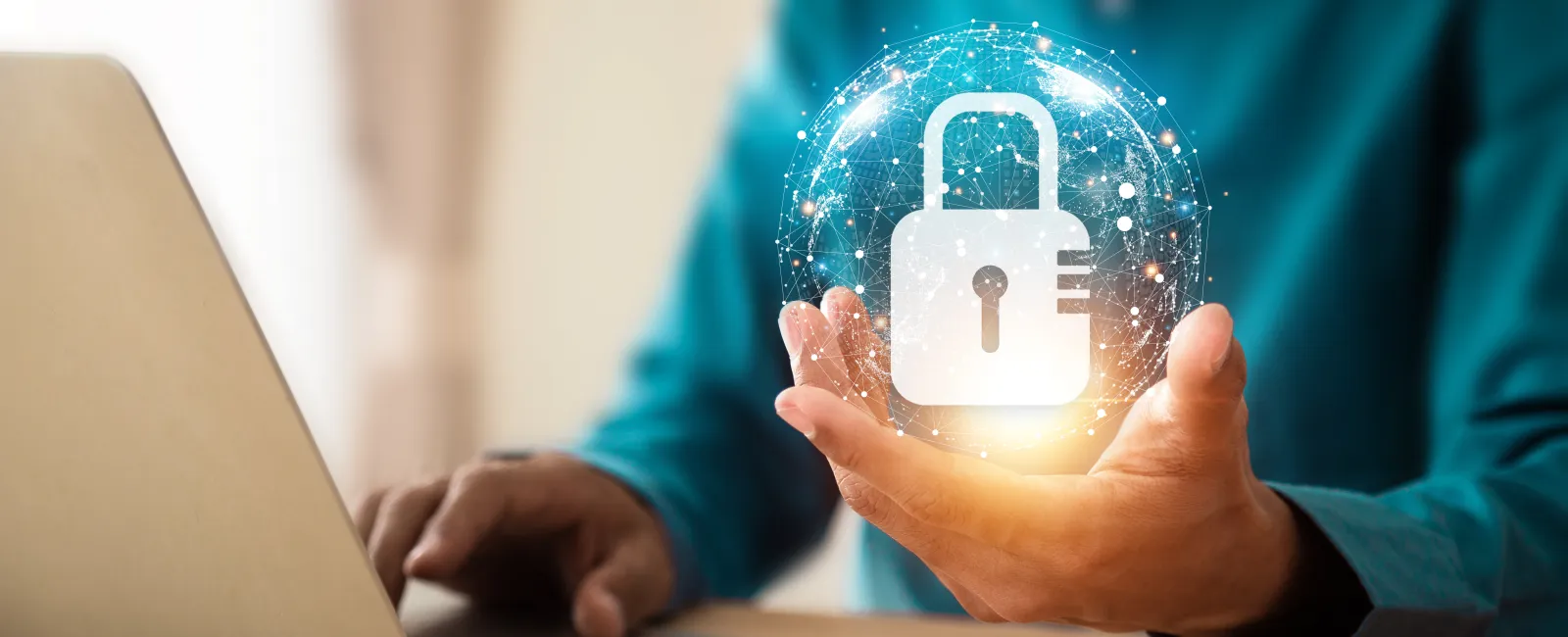 Person using laptop with digital padlock hologram symbolizing cybersecurity and data protection in hand.