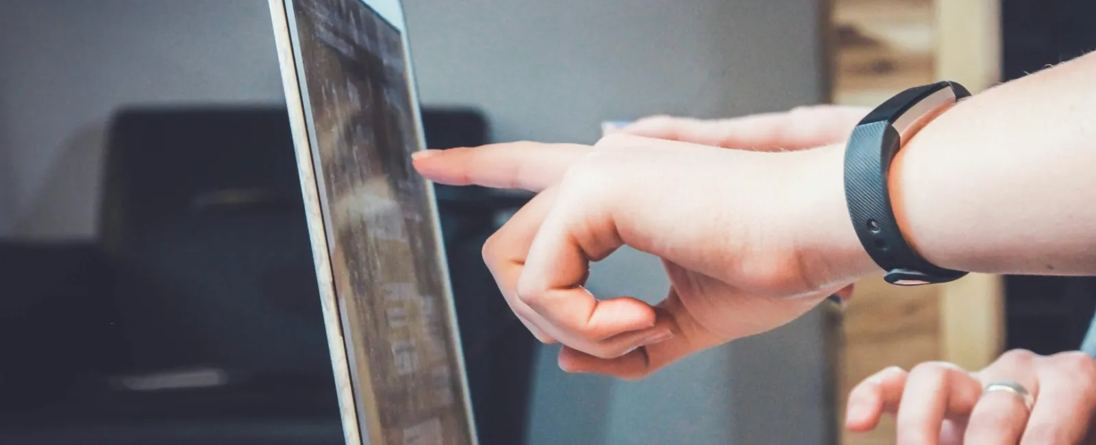Close-up of hands interacting with a laptop screen, showcasing collaboration and technology.