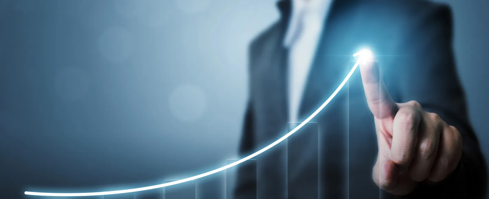 Businessman pointing to a glowing upward graph line representing growth and success.