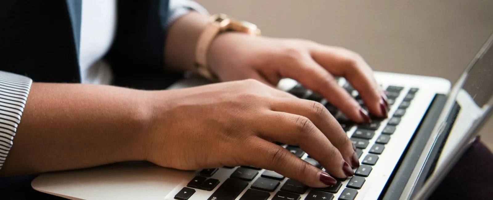 Close-up of hands typing on a laptop keyboard, showcasing modern working environment and productivity.