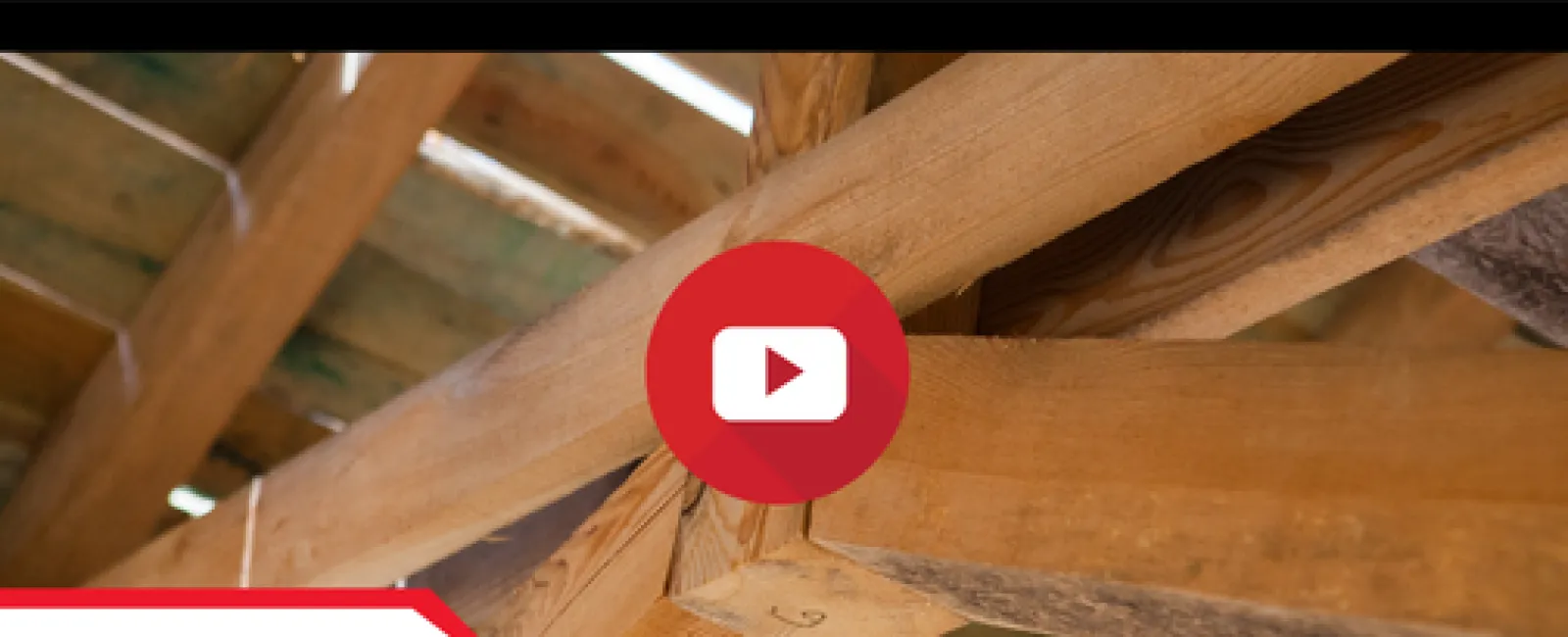 Close-up of a cracked wooden roof truss showing structural damage in a house under construction.